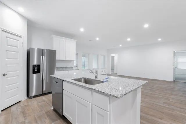 a kitchen with stainless steel appliances granite countertop a sink and a refrigerator