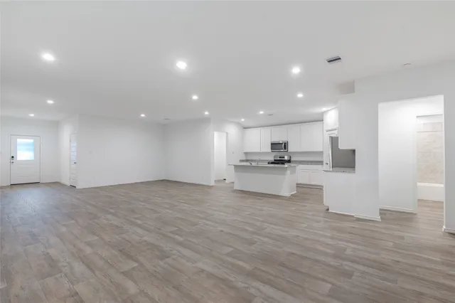 a view of kitchen with kitchen island microwave and stove top oven