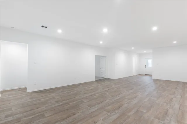 an empty room with wooden floor and natural light