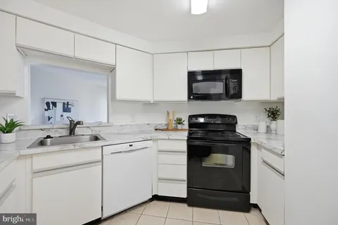 a kitchen with white cabinets and appliances