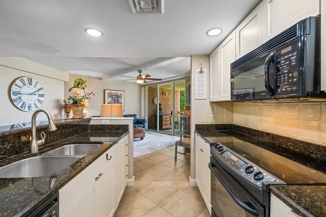 a kitchen with granite countertop a stove a sink and a microwave