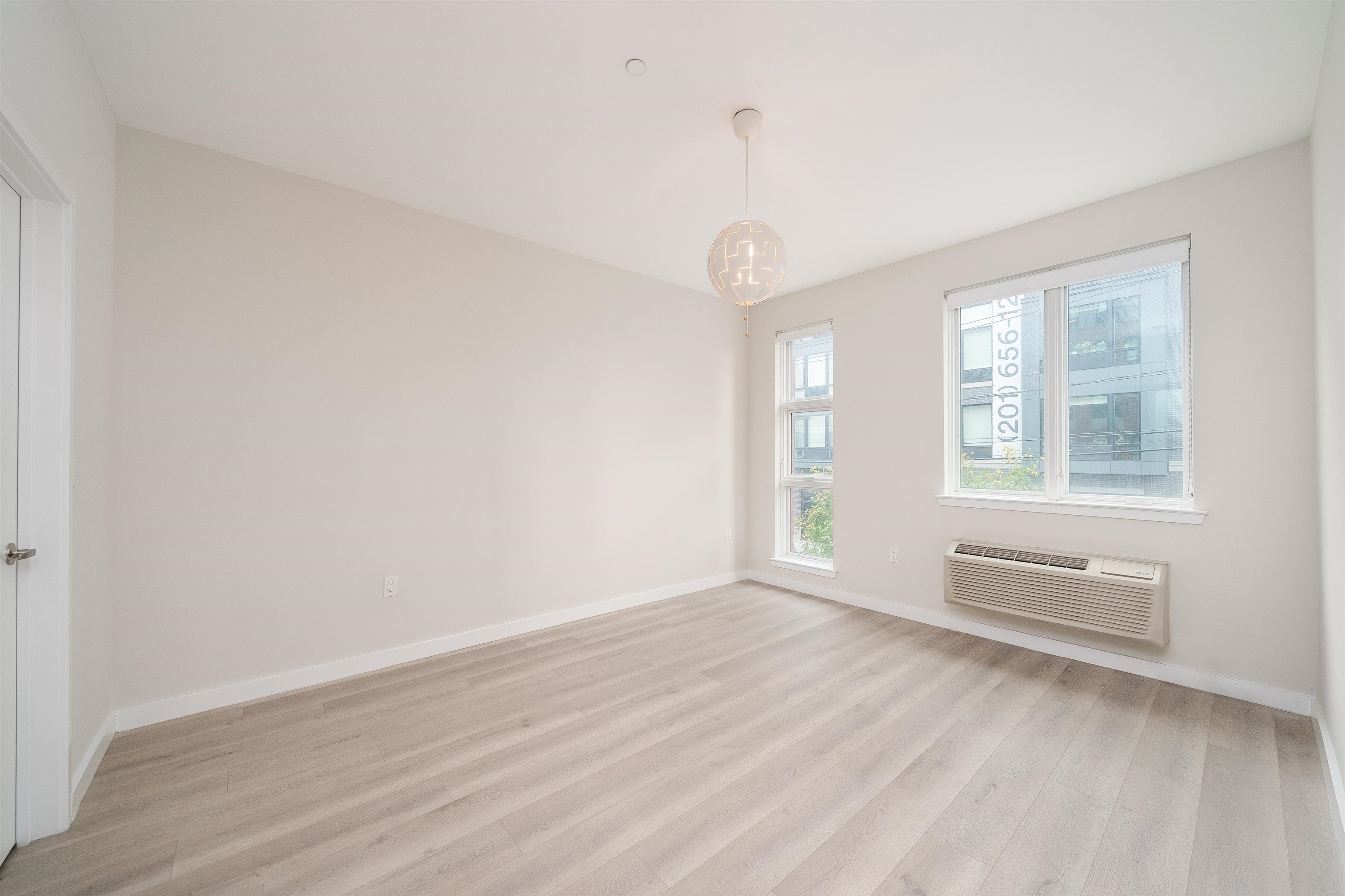 16 Bennett Street, Unit 504 Jersey City, NJ 07304 - Photo 12 of 24 an empty room with wooden floor and windows