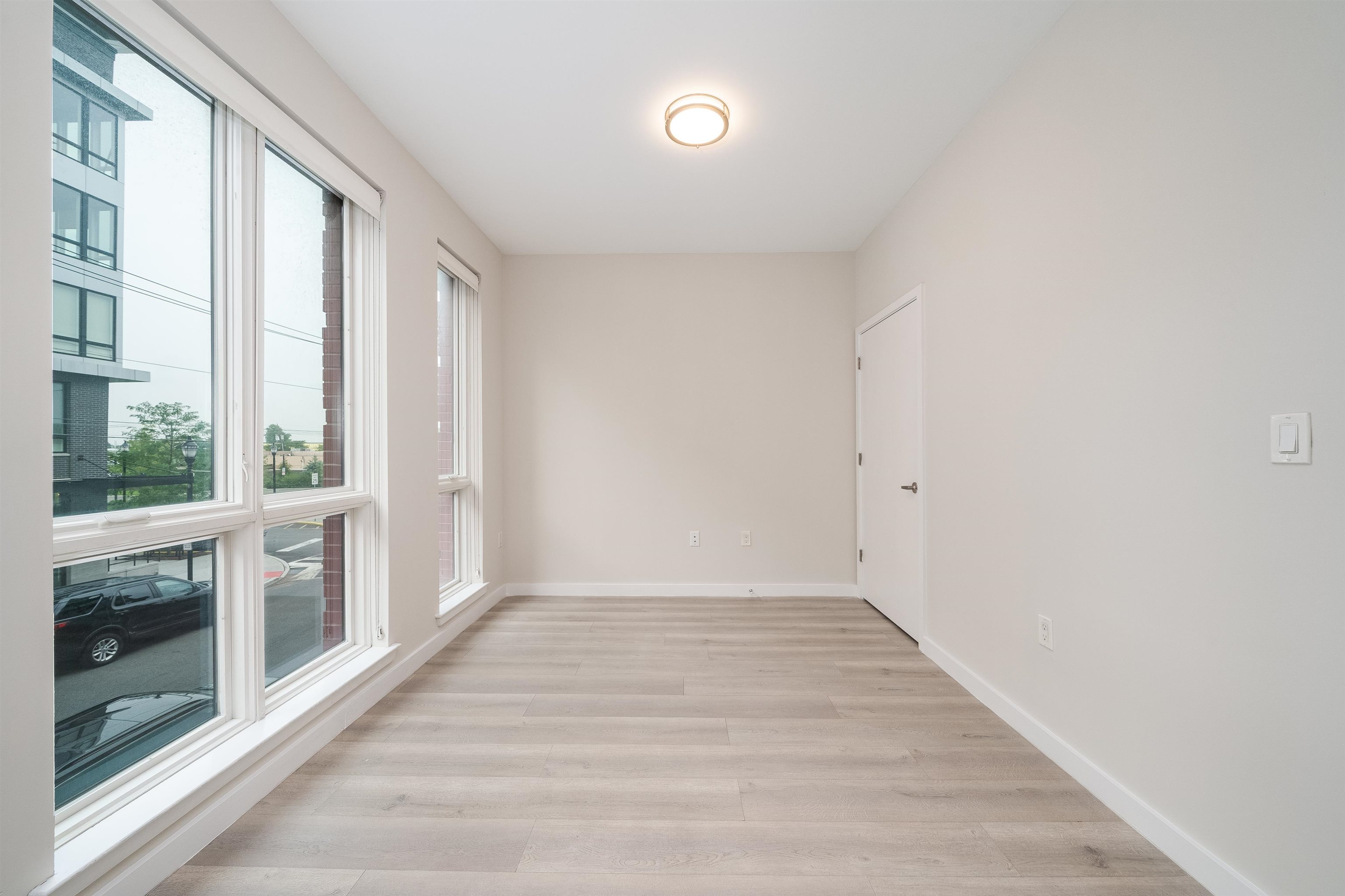 16 Bennett Street, Unit 504 Jersey City, NJ 07304 - Photo 8 of 24 a view of an empty room with a fireplace and windows
