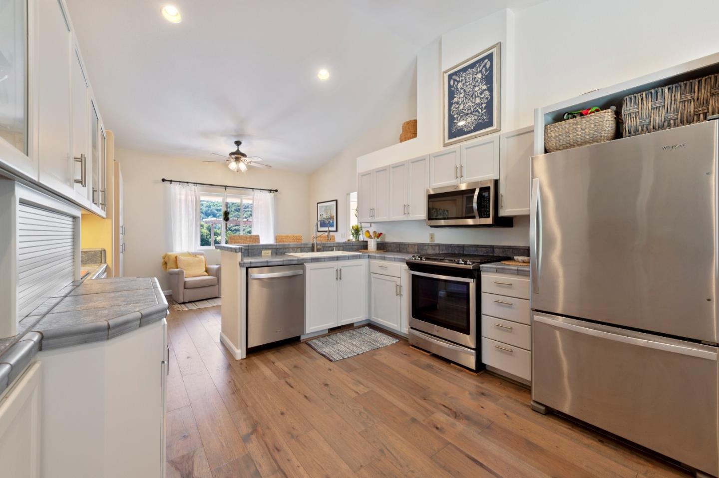 481 Maher Road Watsonville, CA 95076 - Photo 13 of 34 a kitchen with a refrigerator a stove top oven a sink dishwasher and white cabinets with wooden floor