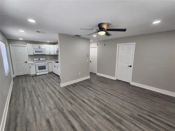 a view of an empty room with wooden floor