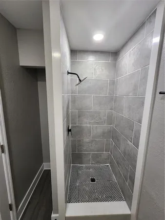 a view of an empty room with wooden floor & closet