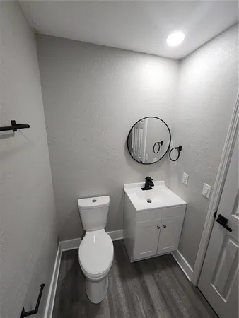a view of an empty room with wooden floor and closet