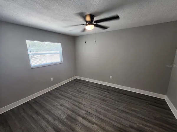 an empty room with wooden floor & closet area
