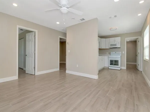a kitchen with stainless steel appliances granite countertop a refrigerator a stove a sink and white cabinets