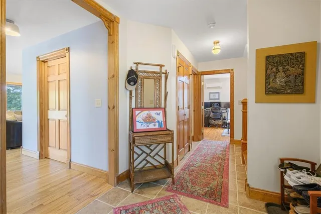 a view of a hallway with wooden floor and furniture