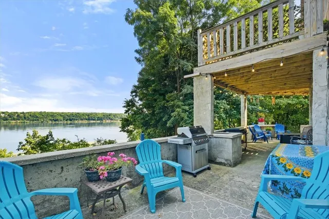 a view of an chairs and table in the patio next to a yard