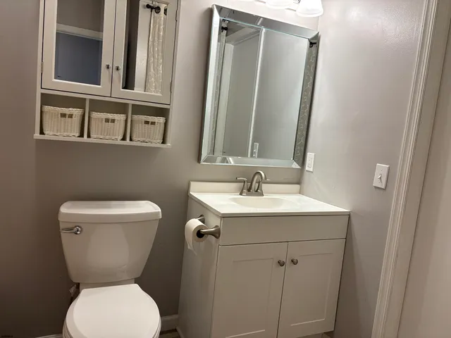 a bathroom with a toilet sink and mirror