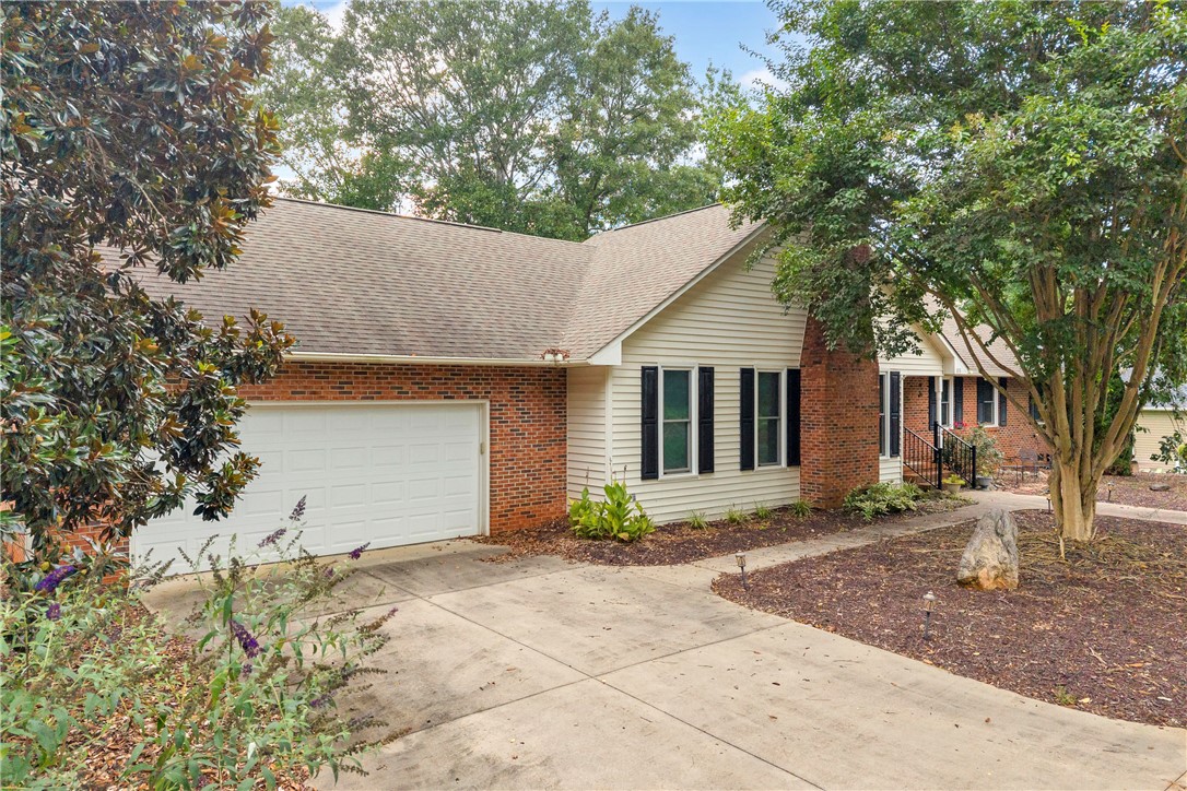 103 Colleton Court Clemson, SC 29631 - Photo 42 of 49 Mature trees frame a classic brick and siding exterior with an attached garage.