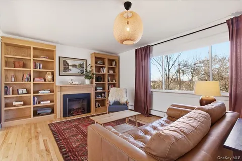 a living room with furniture fireplace and a large window