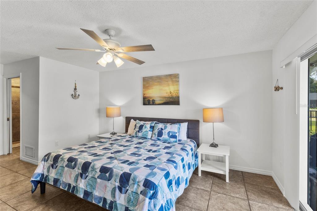 433 Whitfield Avenue Sarasota, FL 34243 - Photo 23 of 46 a bedroom with a bed and a chandelier