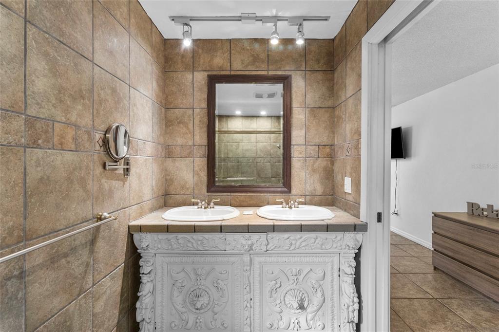 433 Whitfield Avenue Sarasota, FL 34243 - Photo 26 of 46 a bathroom with a granite countertop sink a mirror and shower