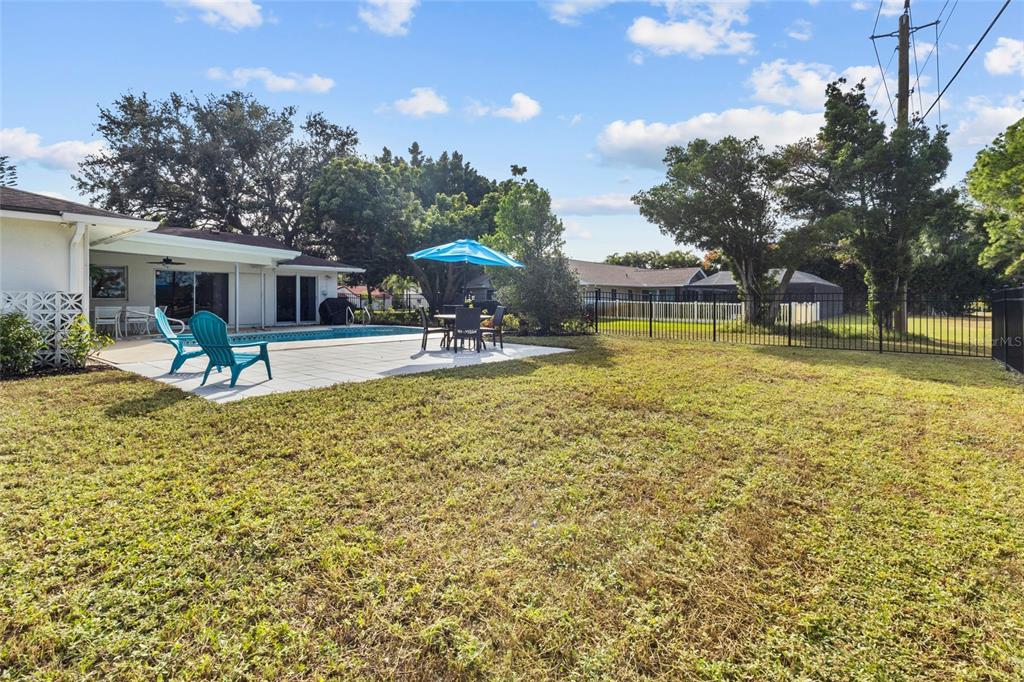 433 Whitfield Avenue Sarasota, FL 34243 - Photo 36 of 46 a view of a swimming pool with a table and chairs under an umbrella