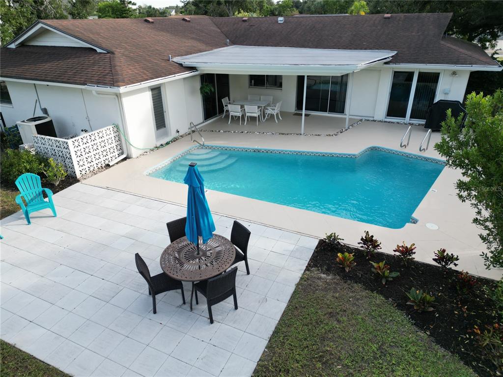 433 Whitfield Avenue Sarasota, FL 34243 - Photo 42 of 46 a view of a patio with table and chairs potted plants and a palm tree