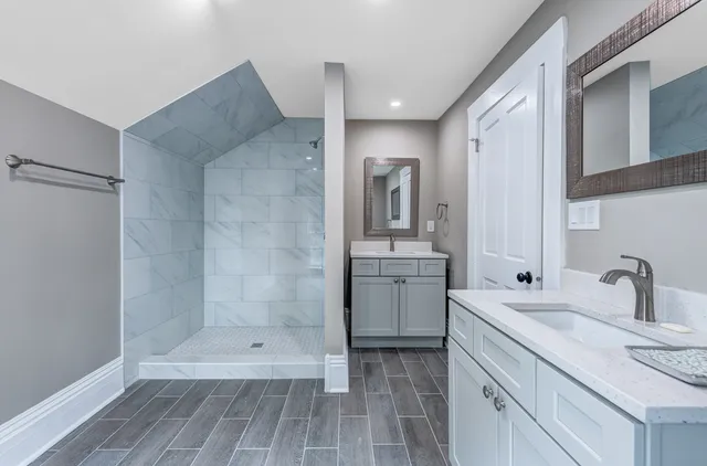 a bathroom with a sink shower and a mirror