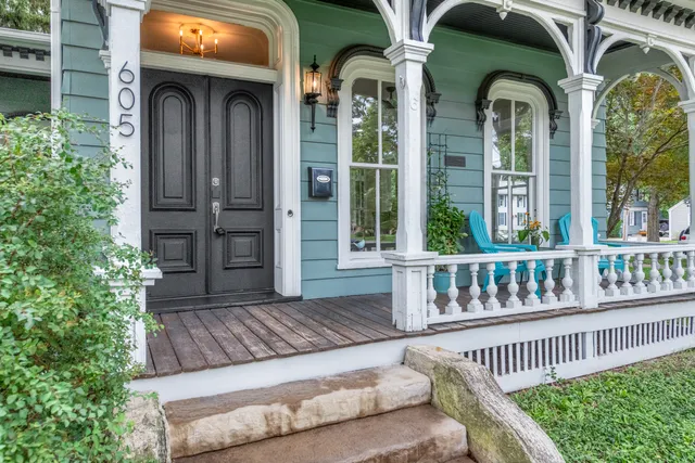 a view of a brick house with large windows and a flower plants in front of house
