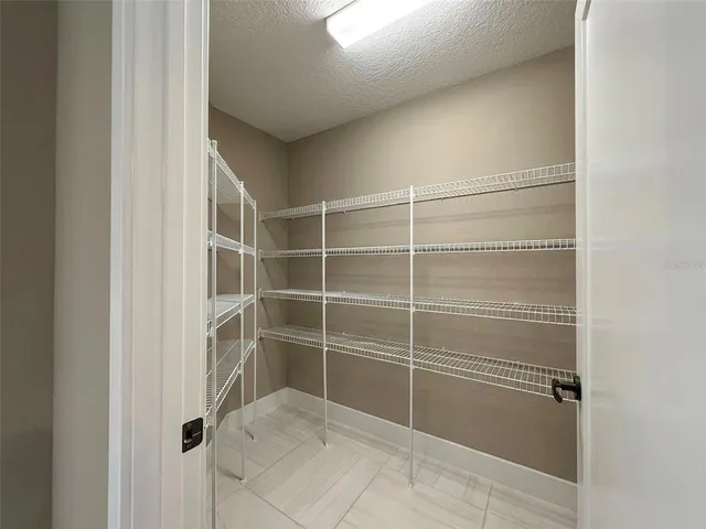 a kitchen with stainless steel appliances granite countertop a refrigerator a stove a sink dishwasher a dining table and chairs with wooden floor