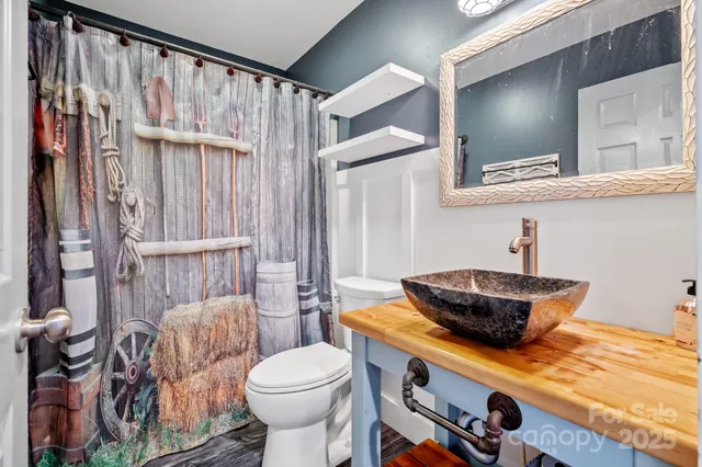 a bathroom with a granite countertop sink a toilet and a mirror