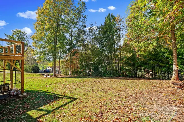 a view of a yard with trees in the background
