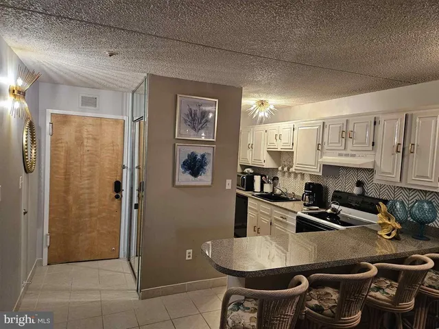 a kitchen with stainless steel appliances granite countertop a sink refrigerator and cabinets