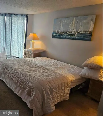 a bedroom with a bed and painting on the wall