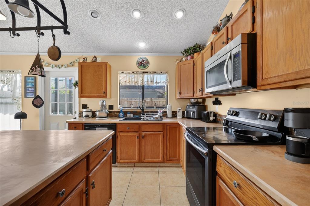 562 Hassocks Loop Lake Mary, FL 32746 - Photo 12 of 34 a kitchen with stainless steel appliances granite countertop a sink a stove and cabinets