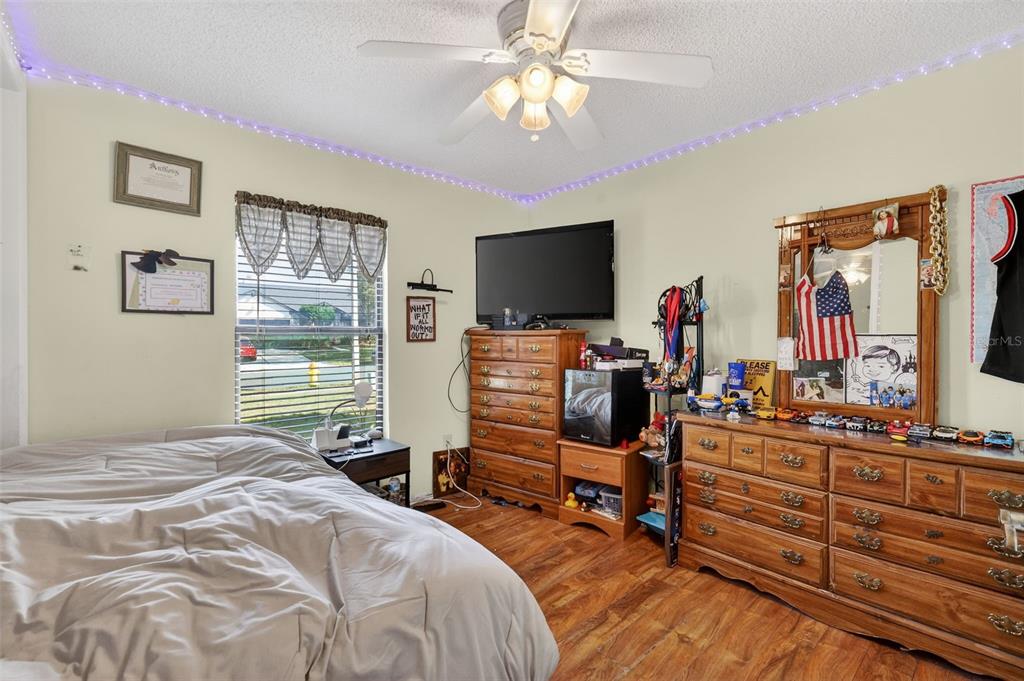 562 Hassocks Loop Lake Mary, FL 32746 - Photo 29 of 34 a bedroom with a bed and a flat tv screen on dresser