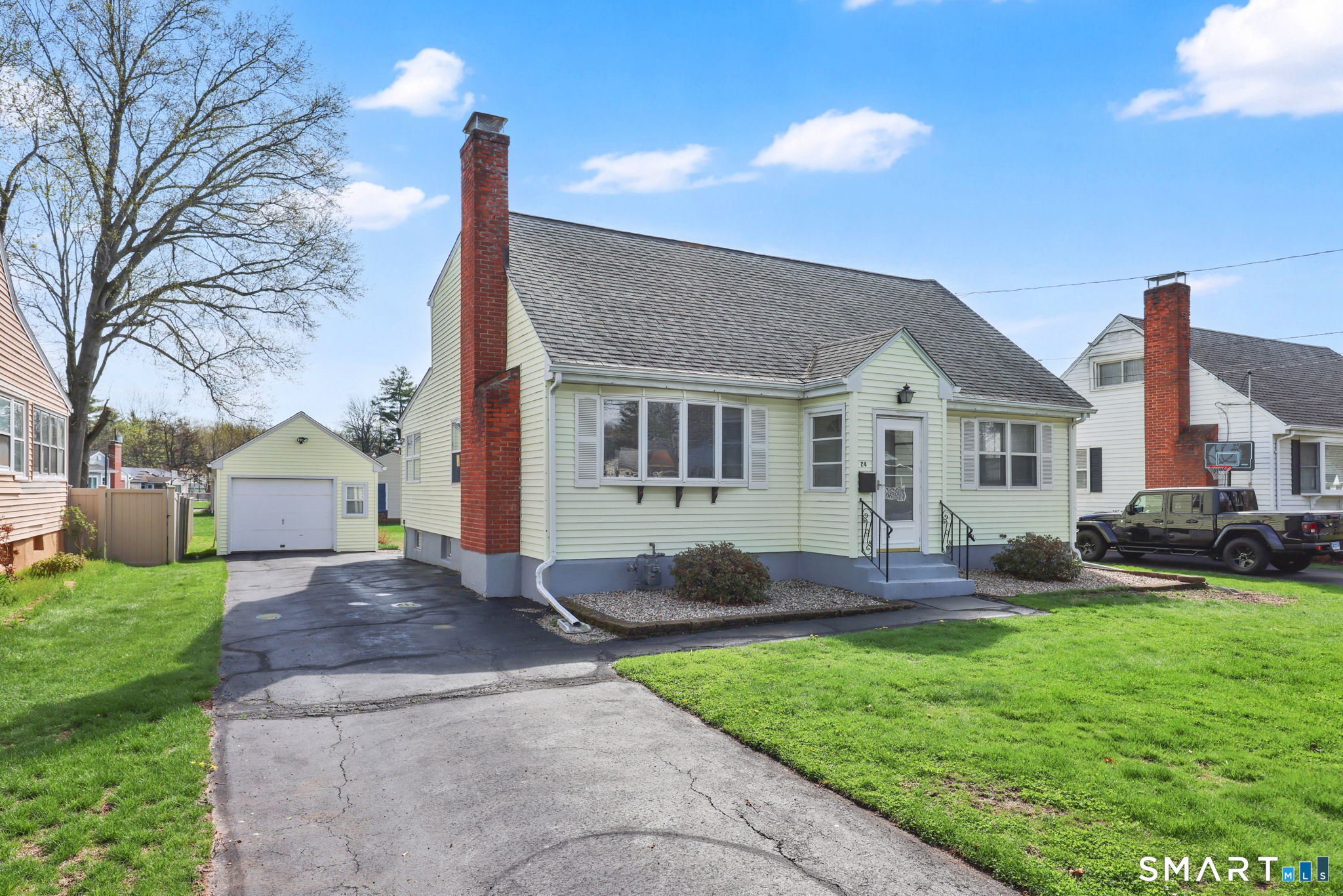 24 Madsen Road West Hartford, CT 06110 - Photo 3 of 38 a front view of a house with a yard and outdoor seating