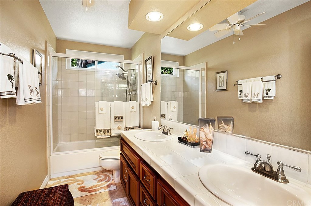 30 Santa Clara San Clemente, CA 92672 - Photo 20 of 31 Guest bathroom upstairs has dual vanities, ceiling fan, and Travertine flooring.