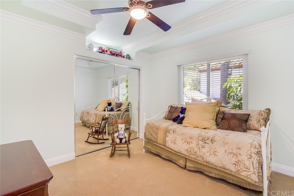 30 Santa Clara San Clemente, CA 92672 - Photo 24 of 31 Upstairs guest bedroom with ceiling fan, mirrored closet doors, and raised ceiling with crown molding.