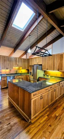 a kitchen with stainless steel appliances granite countertop a sink and wooden cabinets