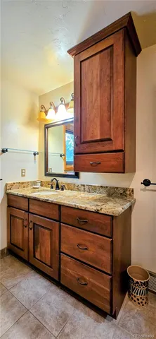 a bathroom with a granite countertop sink and mirror