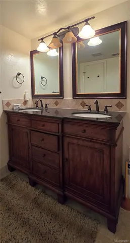 a bathroom with a double vanity sink and a mirror