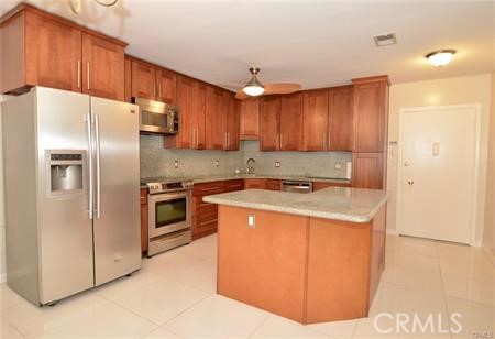 a kitchen with stainless steel appliances granite countertop a refrigerator a sink a stove and a refrigerator with wooden cabinets