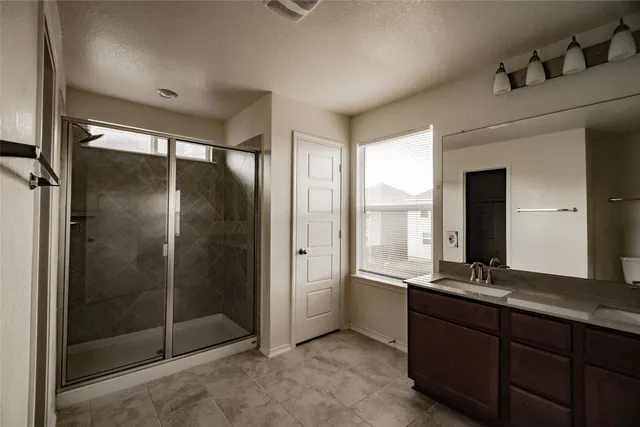 a spacious bathroom with a granite countertop sink and a mirror