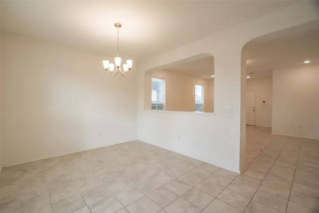 an empty room with chandelier fan