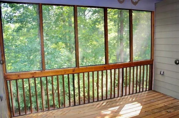 a view of a wooden balcony with a yard