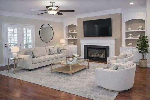 a living room with couches a fireplace and a flat screen tv