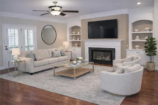 a living room with couches a fireplace and a flat screen tv