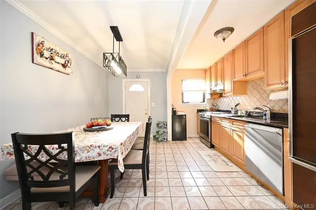 a kitchen with a dining table chairs and a refrigerator