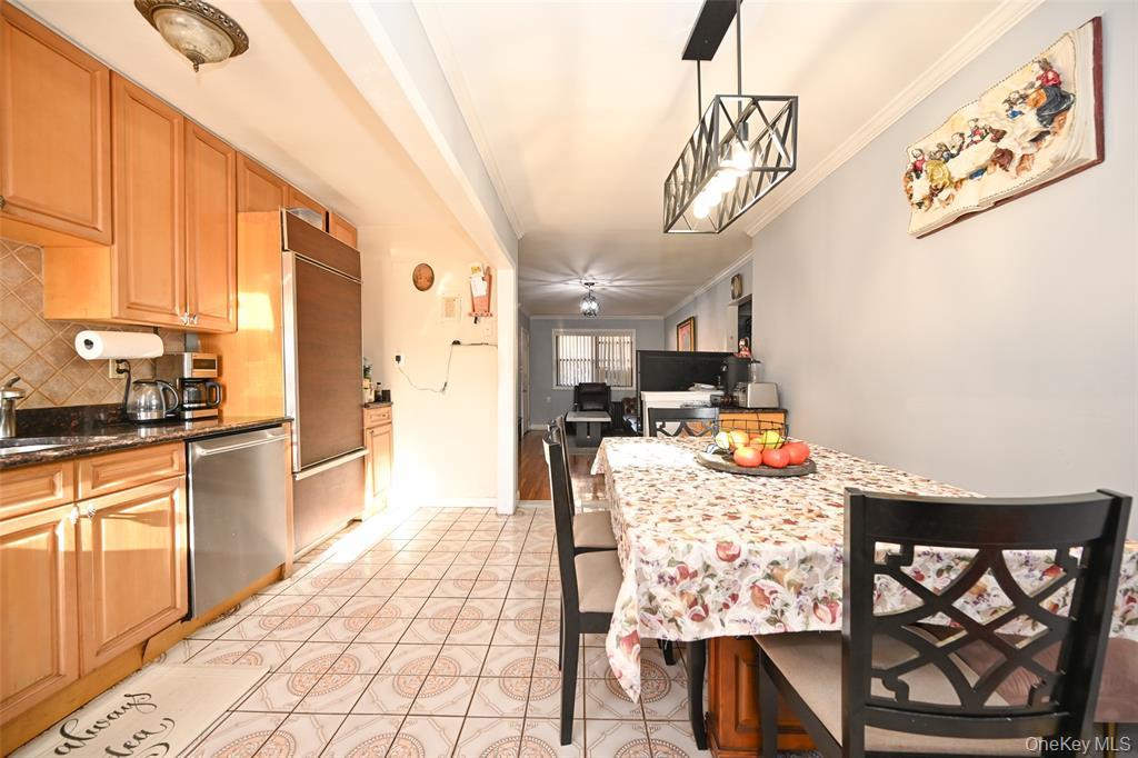 72-08 150th Street, Unit 199A Queens, NY 11367 - Photo 8 of 14 a kitchen with stainless steel appliances kitchen island granite countertop a refrigerator and microwave