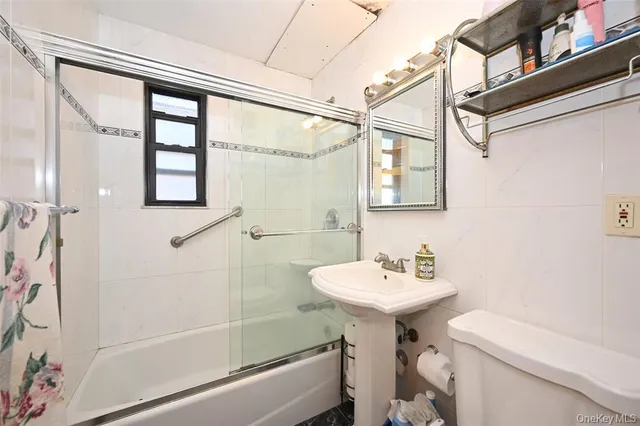 a bathroom with a sink a mirror toilet and bathtub