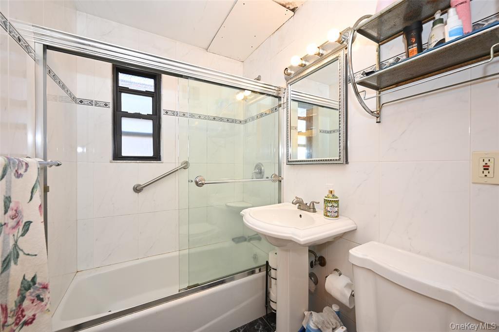 72-08 150th Street, Unit 199A Queens, NY 11367 - Photo 9 of 14 a bathroom with a sink a mirror toilet and bathtub