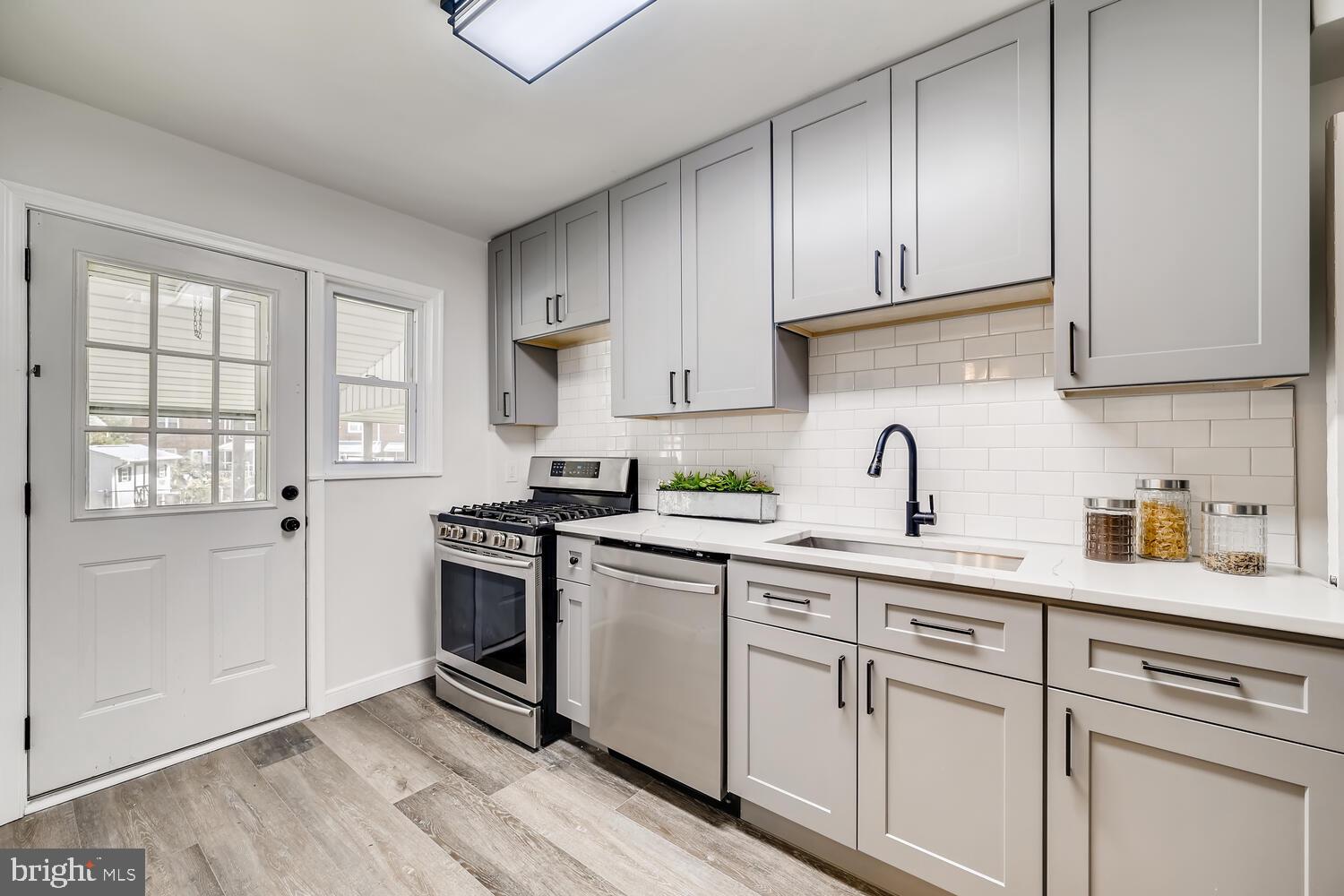 2720 Moorgate Road Baltimore, MD 21222 - Photo 11 of 28 a kitchen with white cabinets stainless steel appliances and sink
