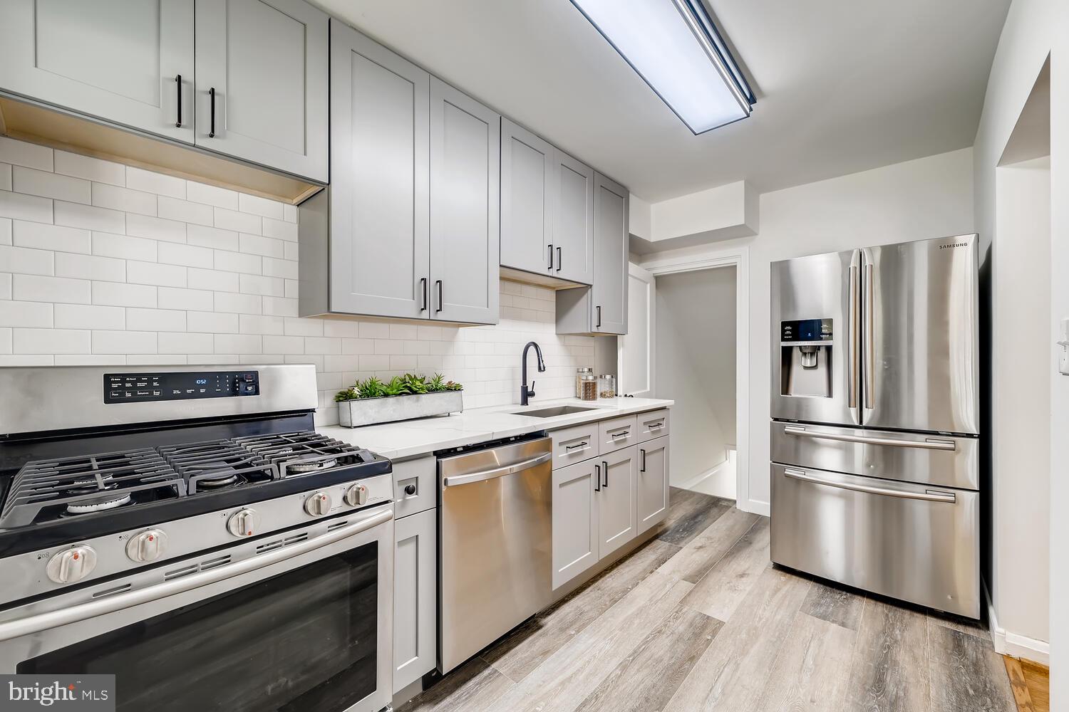 2720 Moorgate Road Baltimore, MD 21222 - Photo 12 of 28 a kitchen with cabinets stainless steel appliances and wooden floor