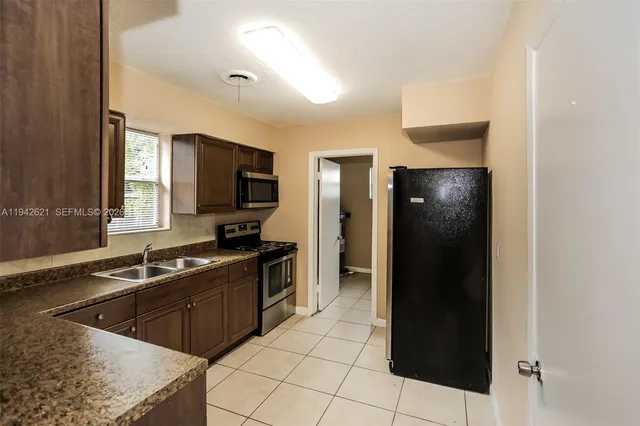 a kitchen with stainless steel appliances granite countertop a refrigerator and a sink